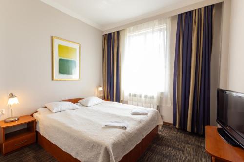 a hotel room with a bed and a television at Noclegi Stadion Bed & Breakfast in Warsaw