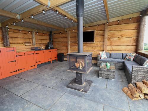 a living room with a fireplace in a wooden cabin at Rhosydd in Ruthin
