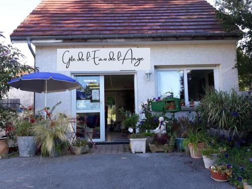 a flower shop with an umbrella in front of it at Gîte de l’eau de l’ange in Audelange
