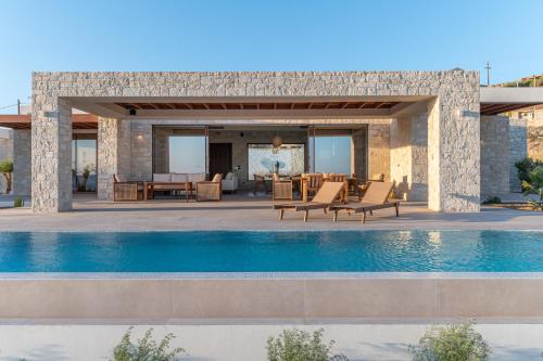 a villa with a swimming pool and a patio at POEMO VILLAS in Ierápetra