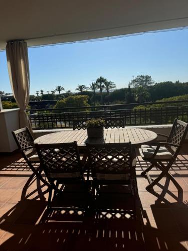 einen Holztisch und Stühle auf einer Terrasse mit Aussicht in der Unterkunft Apartamento con vistas para 5 personas in El Rompido