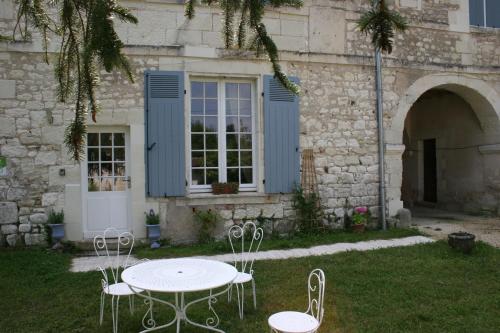 a table and chairs in front of a building at Grand gite en rez-de-jardin in Saint-Aignan