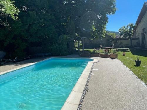 une grande piscine bleue dans une cour dans l'établissement La Pastorale, à La Bâtie-Neuve
