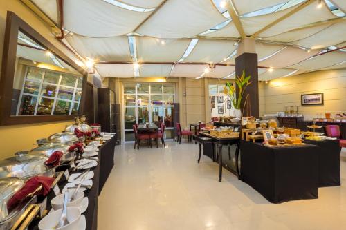 a restaurant with a buffet line with tables at Mercure Hanoi La Gare Hotel in Hanoi