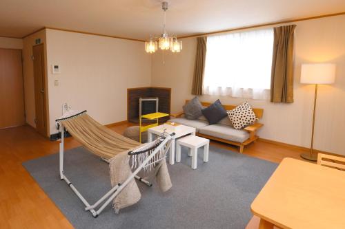 a living room with a hammock and a couch at Rose Garden in Asahikawa