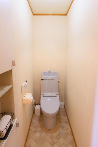 a bathroom with a white toilet in a room at Rose Garden in Asahikawa