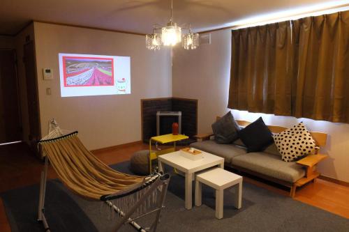 a living room with a couch and a hammock at Rose Garden in Asahikawa