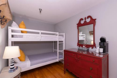 a bedroom with two bunk beds and a mirror at Chapter House in Yarmouth