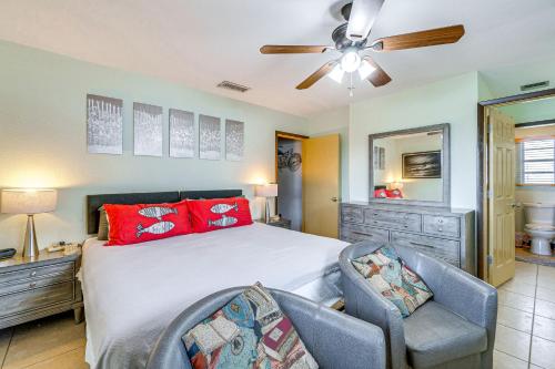 a bedroom with a bed with two chairs and a ceiling fan at Canalfront Retreat with Heated Pool and Hot Tub! in Port Charlotte