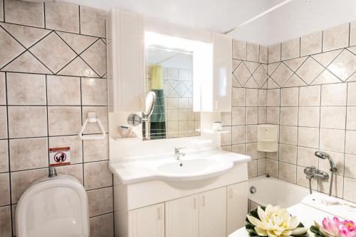 a bathroom with a sink and a toilet and a tub at SounioKallisti Suites 3 in Análipsis