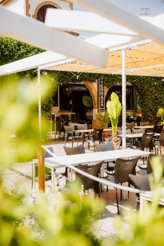 a restaurant with tables and chairs in a garden at Escua in Archidona