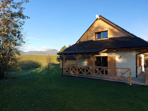 a house with a thatched roof on a field at CHALUPY TRI GROŠE VLAŠKY in Bešeňová