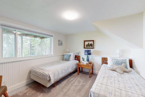 ein Schlafzimmer mit zwei Betten und einem Fenster in der Unterkunft Sea Bell Retreat in Phippsburg