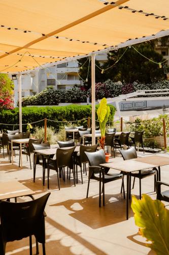 an outdoor patio with tables and chairs and umbrellas at Escua in Archidona