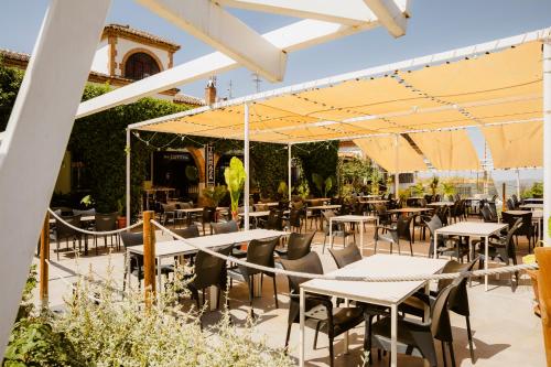 an outdoor patio with tables and chairs and umbrellas at Escua in Archidona