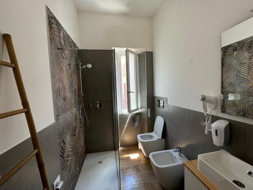 a bathroom with a shower and a toilet and a sink at Montecristo B&B in Grosseto