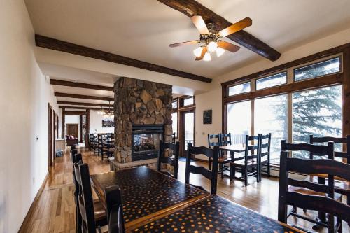 een eetkamer met een tafel en een open haard bij Taharaa Mountain Lodge in Estes Park