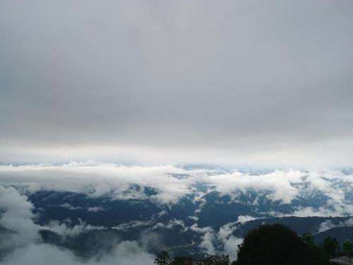 a view of the clouds and mountains from above at White Sea Homestay in Kurseong