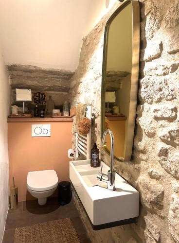 une salle de bain avec un lavabo blanc et un miroir dans l'établissement La Cigalou - Bonnieux Centre, à Bonnieux