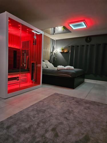 Una habitación con luces rojas y una cama en una habitación. en So SWEET, en Oupeye