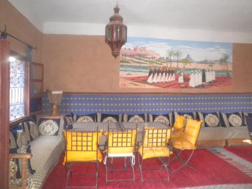 a living room with a couch and a painting on the wall at Hamada Du Draa in Mhamid