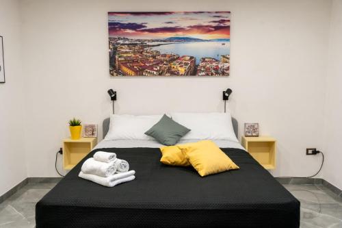 a bed with two towels and a painting on the wall at BeB Sole in San Giorgio a Cremano