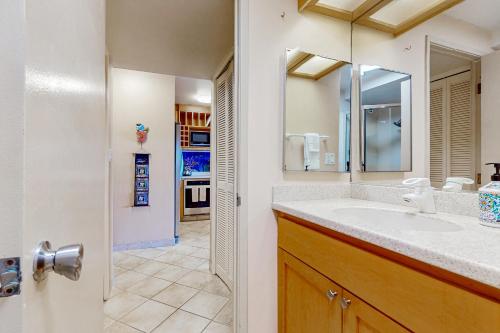 a bathroom with a sink and a mirror at Kona Ali'i 502 in Kailua-Kona