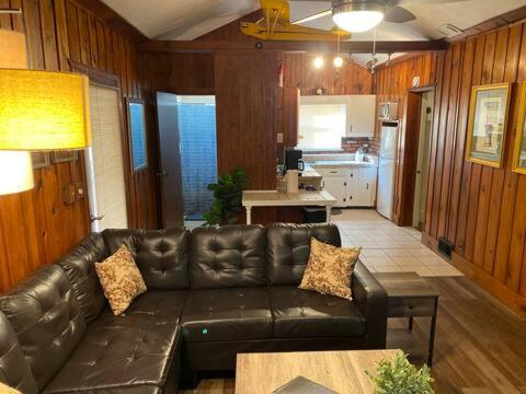 Una sala de estar con un sofá de cuero y una cocina. en Take me to the River!, en Zanesville
