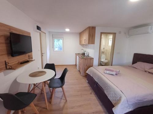 a bedroom with a bed and a table and chairs at Apartmani Marinee in Donja Jošica