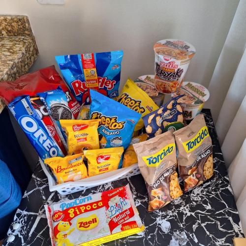 a pile of chips and other snacks on a table at Residencial Luce Del Sole - Apto Nº 2 in Joinville