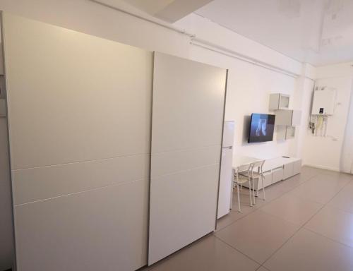 a white room with a white wall and a tv at Marina studio in Mamaia Nord