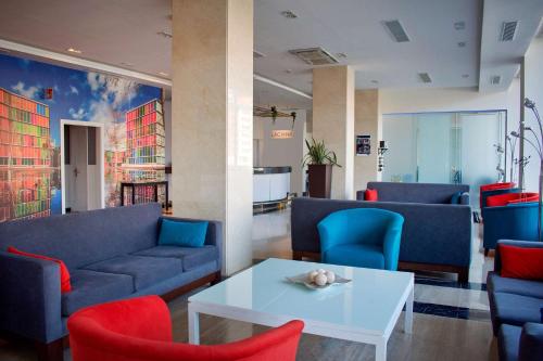 a lobby with couches and a table and chairs at Hotel Zentral León in León