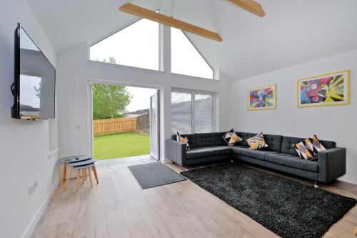 a living room with a couch and a large window at Contemporary Luxury Lodge, Aberdeen West in Blackburn