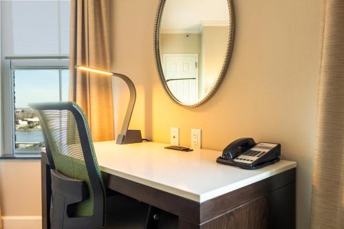 una scrivania con telefono e specchio di Holiday Inn Express Savannah - Historic District a Savannah