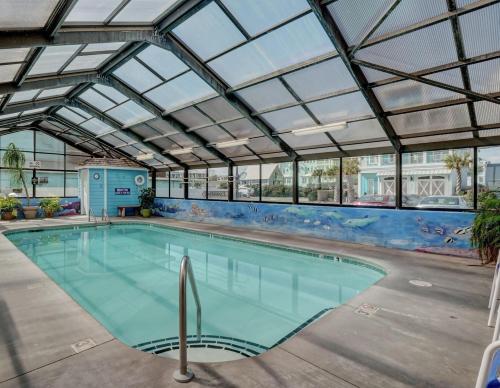 a large swimming pool with a glass ceiling at Octopus Garden 1BR, King Bed, Indoor & Outdoor Pool in Carolina Beach