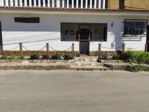 a white house with a gate and a fence at Casa Estação da Paz in Miguel Pereira