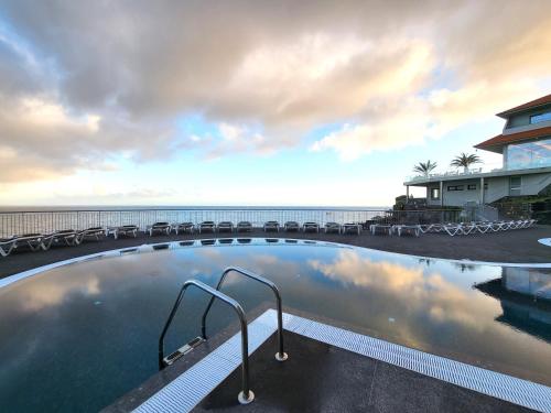 a swimming pool with a view of the ocean at Hotel Royal Orchid in Caniço