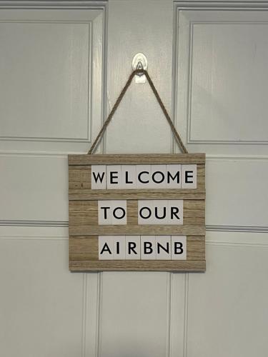 a sign that says welcome to our airplane hanging on a door at Peaceful 1BR easy commute, urban suburban mix feel in Boston in Boston