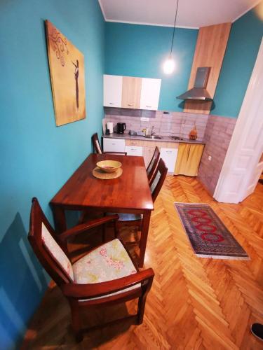 a kitchen with a wooden table and chairs in a room at Sombor 19 Central Apartment in Sombor