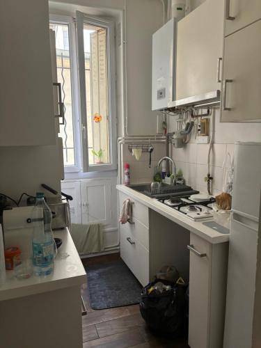 une cuisine avec un évier et une cuisinière four supérieur dans l'établissement Appartement 2 pièces 58 m2 paris Alésia, à Paris