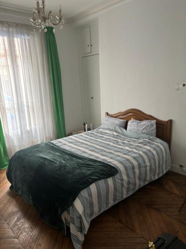 - une chambre avec un lit doté de rideaux verts et d'un lustre dans l'établissement Appartement 2 pièces 58 m2 paris Alésia, à Paris