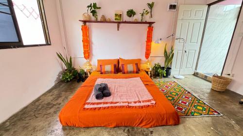 a bedroom with an orange bed in a room at Baan YentaFo - Pink House 4th floor in Chinatown