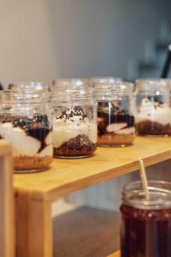 a group of desserts in jars on a wooden table at YeeOn Living-Well Boutique City Hotel Gythio in Gythio