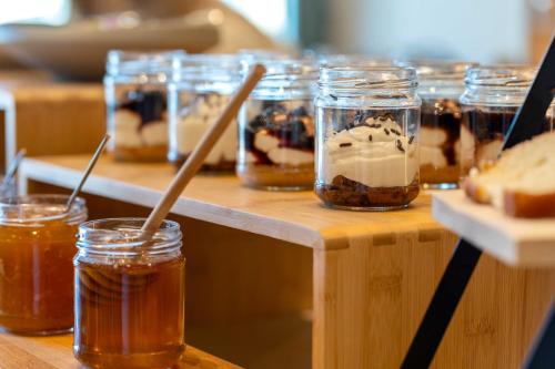 a row of jars of honey and desserts on a table at YeeOn Living-Well Boutique City Hotel Gythio in Gythio