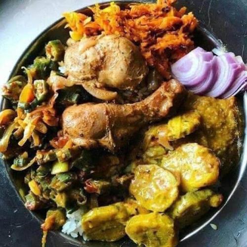 a plate of food with chicken and vegetables on a table at Meemure Rawana Adawiya in Meemure