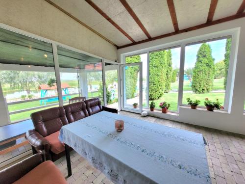 un soggiorno con tavolo, sedie e finestre di Casa Obreja a Parcheş