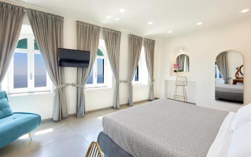 a bedroom with a bed and a tv and windows at Residenza D'epoca Tamara in Castellabate