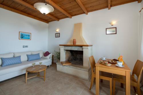 a living room with a couch and a fireplace at Stefanos Village Hotel in Plakias