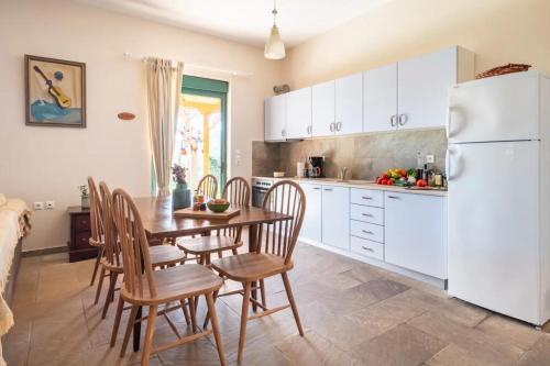 a kitchen with a table and chairs and a white refrigerator at Agrotospita Country Houses in Nafplio