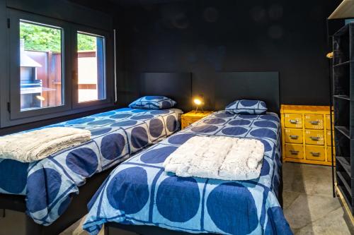 a bedroom with two beds and a window at Black House- Sorprendente casa estilo industrial in Olot
